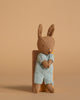 A Maileg Fully Furnished Suitcasa with Micro Bunny Set features a brown stuffed bunny in a light blue knitted outfit, perfect for adding charm to any miniature dollhouse, shown against a solid beige background.
