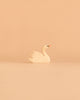 The Ostheimer Handmade Wooden Swan Girl Set, featuring a small handcrafted wooden swan with painted details, sits centered on a plain beige background, embodying the sustainably sourced craftsmanship for which Ostheimer toys are renowned.