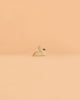 An Ostheimer Handmade Wooden Swan Girl Set, inspired by classic handcrafted wooden toys, is centered on a smooth, peach-colored background with plenty of empty space around it.