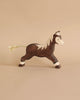 A handcrafted brown Holztiger Handmade Wooden Horses Set toy with a white mane and a rope tail.