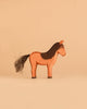 The Ostheimer Horse - Iceland Hrokur, a handcrafted wooden toy horse featuring a painted brown body with a black mane and tail, stands on a beige background, exemplifying the charm of sustainably sourced Ostheimer toys.