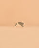 A handcrafted pig figurine with black spots and a curled tail from the Ostheimer Handmade Wooden Farm Animals Set, made from sustainably sourced materials in the distinctive Ostheimer style, is displayed against a plain beige background.