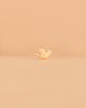 A charming, small, light-colored bird figurine with an orange beak from the Ostheimer Handmade Wooden Farm Animals Set is centered on a smooth, beige surface with a minimalist beige background—an elegant example of handcrafted wooden toys.