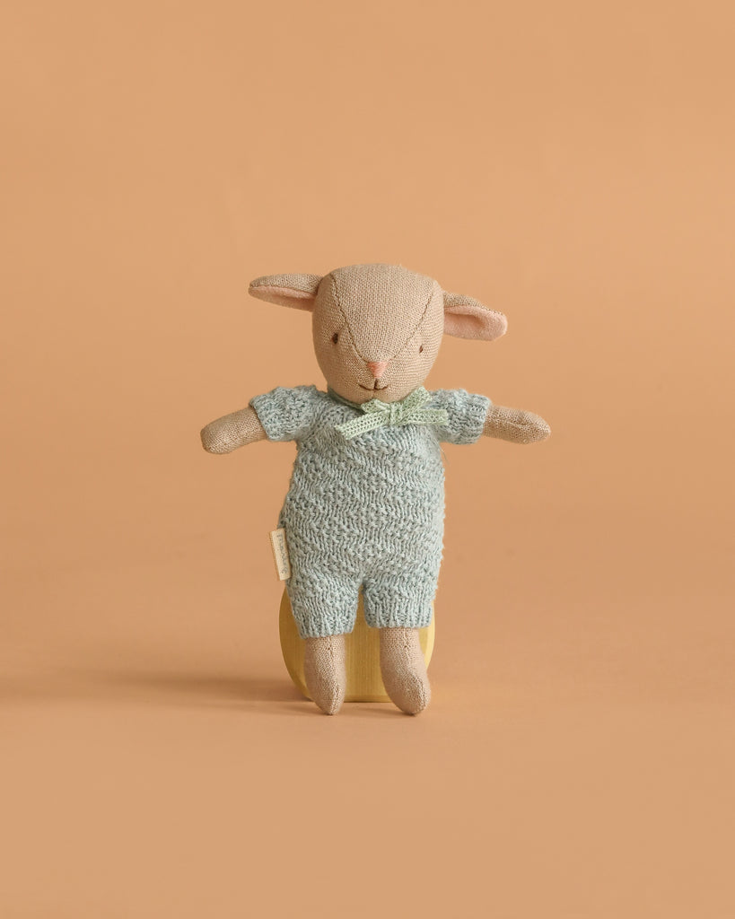 The Maileg Easter Egg features a lamb doll dressed in extra clothing, standing upright against a plain peach-colored background.