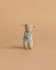 A Maileg Easter Egg with a plush lamb featuring magnetic hands and extra clothing sits upright against a plain, beige background.