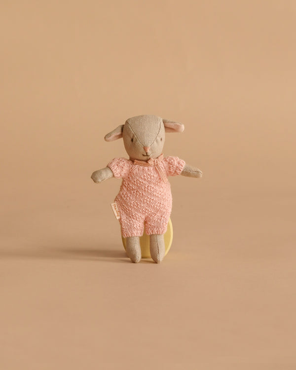 A Maileg Easter Egg with Lamb & Extra Clothing, featuring a small stuffed bunny in a pink knitted outfit, stands upright against a plain beige background.
