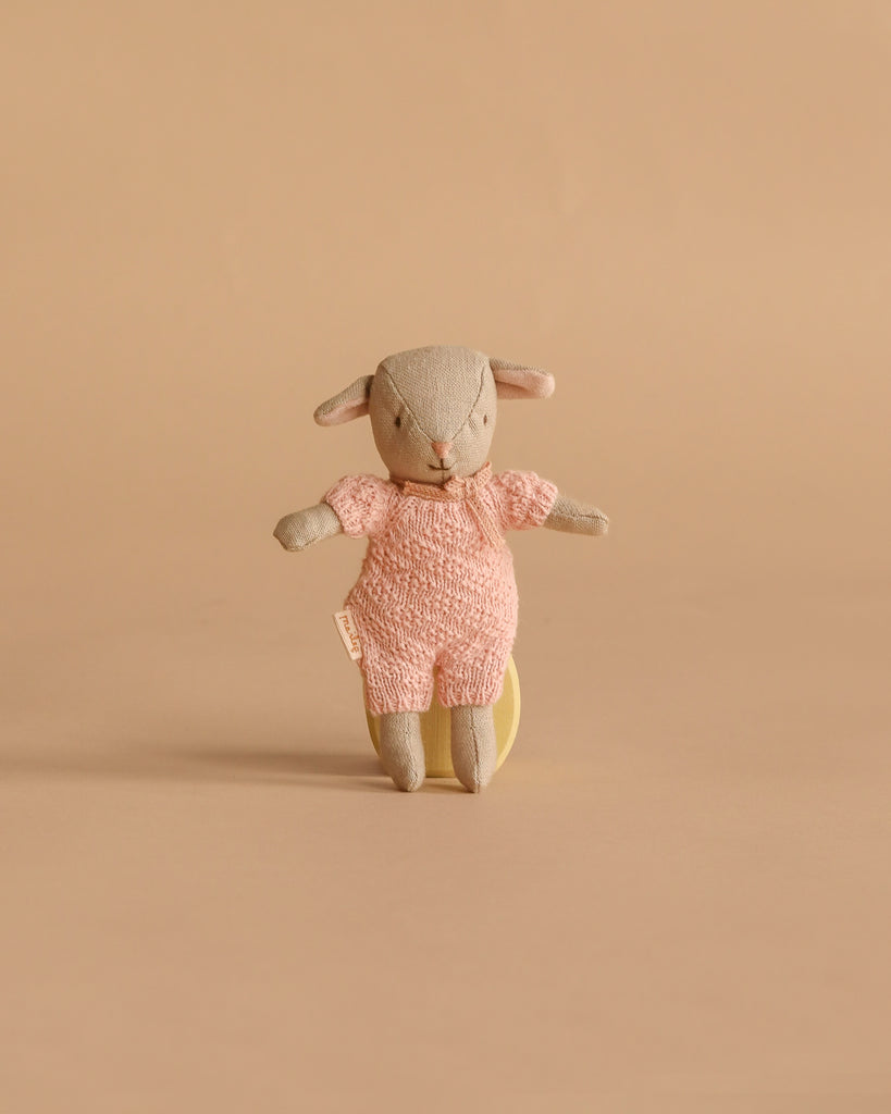 A Maileg Easter Egg with Lamb & Extra Clothing, featuring a small stuffed bunny in a pink knitted outfit, stands upright against a plain beige background.