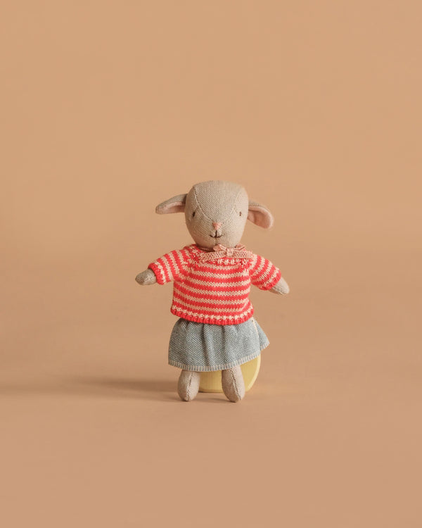 The Maileg Easter Egg with Lamb & Extra Clothing features a small stuffed lamb in a red and white striped sweater and gray skirt, posed upright against a plain light brown background.