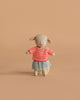The Maileg Easter Egg with Lamb & Extra Clothing features a small stuffed lamb in a red and white striped sweater and gray skirt, posed upright against a plain light brown background.