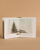 An open copy of "Our Little Adventure at Christmas (Baby's first Christmas)" reveals a badger and fox cub by a decorated tree in a snowy forest, making this beige board book a charming holiday gift for toddlers.