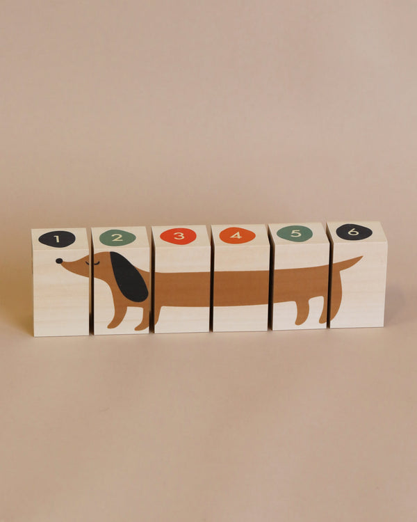 A set of six Uncle Goose Environments Neighborhood Blocks arranged in a row, each featuring a portion of a dachshund and numbered from 1 to 6 against a plain beige background.