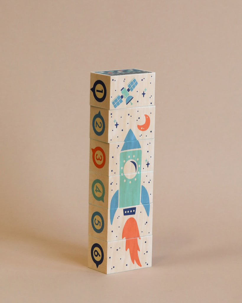 A stack of Uncle Goose Environments Space Blocks with an outer space theme, featuring a rocket ship design on the side, against a plain beige background.