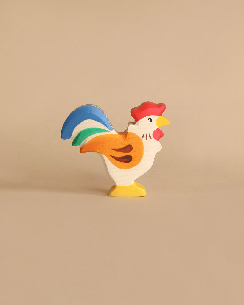 Handmade Holztiger wooden rooster toy from the Holztiger Handmade Wooden Farm Animals Set with red, orange, green, and blue painted details.