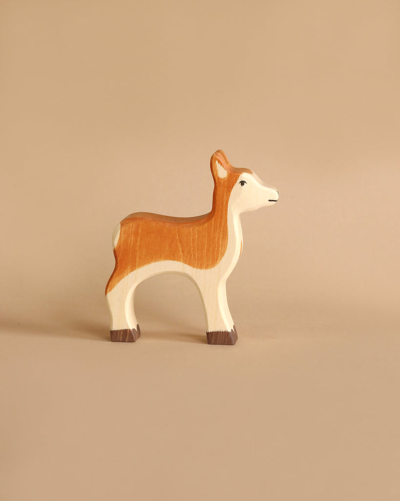 The Holztiger Handmade Wooden Woodland Animals Set features a brown and white deer, crafted from maple and beech wood, standing on a plain beige background.