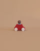 The Lubulona Wooden Car with Figure - Red features a red body, natural wood wheels, and a peg person driver—an eco-friendly toy that sparks imaginative play for kids.