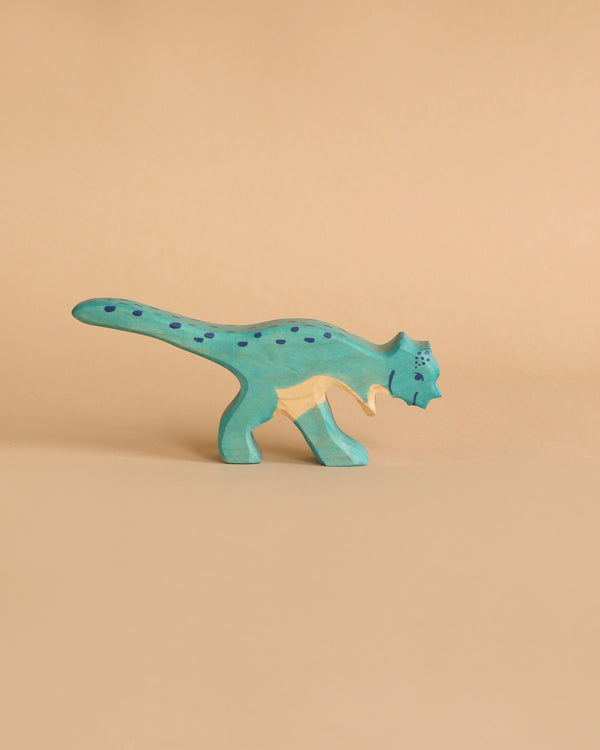 A small, wooden Holztiger Pachycephalosaurus Dinosaur painted light blue with dark blue spots is presented. This handcrafted wood figure stands on two legs with a long tail curving behind it, set against a plain, beige background. Like other HOLZTIGER figures, it exemplifies the quality and charm of being Made in Europe.