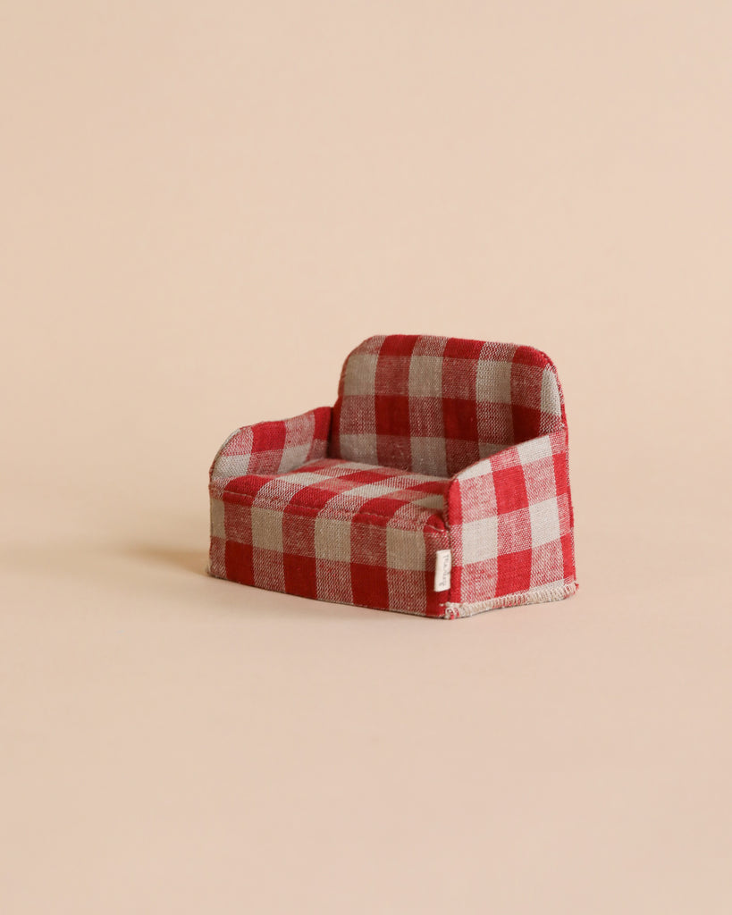 A Maileg Plaid Couch, perfect for your Maileg Gingerbread House, is centered against a beige background. The couch features a classic design with rounded armrests and a slightly reclined backrest. It's an ideal addition to your collection of small Maileg friends, creating a minimalist and tidy setting.
