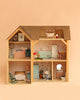 The Maileg Fully Furnished Farmhouse Set + Surprise Gift features a charming wooden dollhouse with four beautifully decorated rooms, complete with adorable miniature furniture and animal figurines. It includes delightful Maileg Mouse Furniture and a variety of dollhouse accessories for the kitchen, bathroom, bedroom, and living area—all presented against a soft peach background.