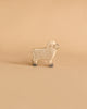 A small wooden sheep from the Holztiger Handmade Wooden Farm Animals Set features a light beige body with subtle swirls and gray accents on its face and feet, styled like classic Holztiger figures, displayed on a plain beige background.