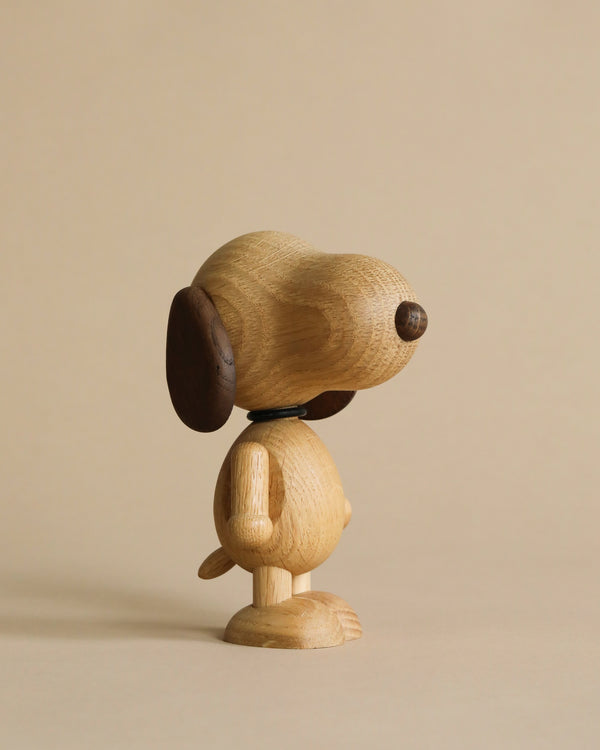 A Boyhood Snoopy, Small sculpture with articulated parts, featuring a round head, large ears, and a simple body on a single stand, set against a neutral beige background.