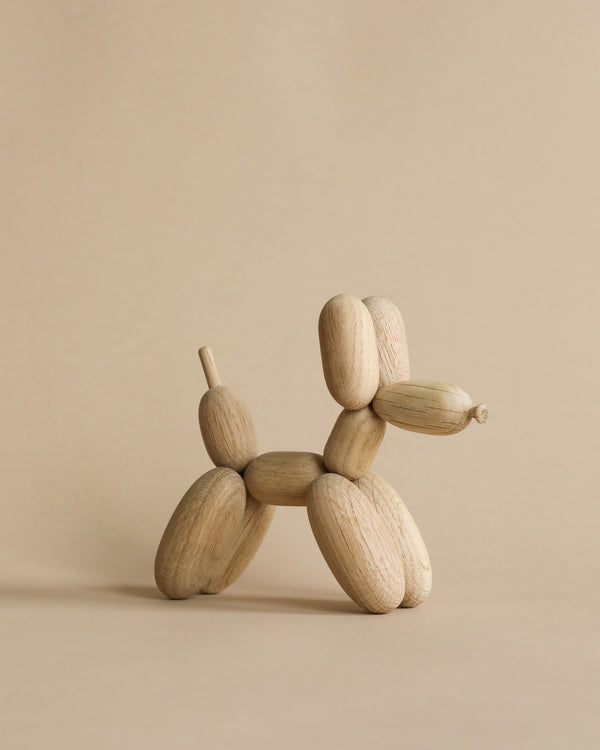 Boyhood Ballon d'Og, Small Oak artist's mannequin posed to resemble a sitting fantasy animal, set against a plain beige background. The figure is crafted from European FSC oak with jointed, adjustable segments.