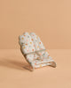 The Maileg Nursery Set features a small, polka-dotted fabric chair with a silver metal frame on a peach surface—perfect for a Maileg Mouse and adding charm to any miniature scene.