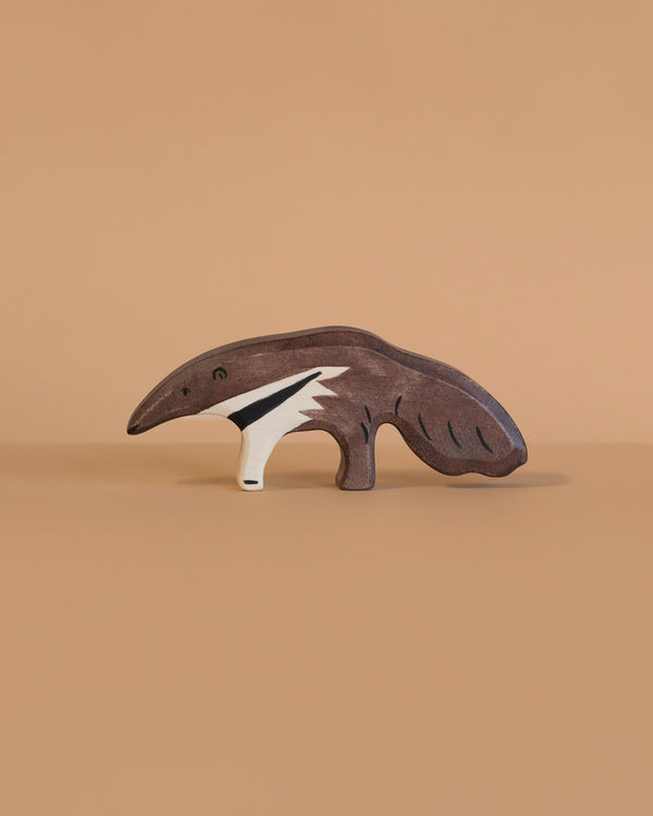 The Holztiger Anteater, a handcrafted wooden toy, features a painted anteater design and sits on a light brown surface with a beige background, showcasing the quality of Holztiger figures made in Europe.