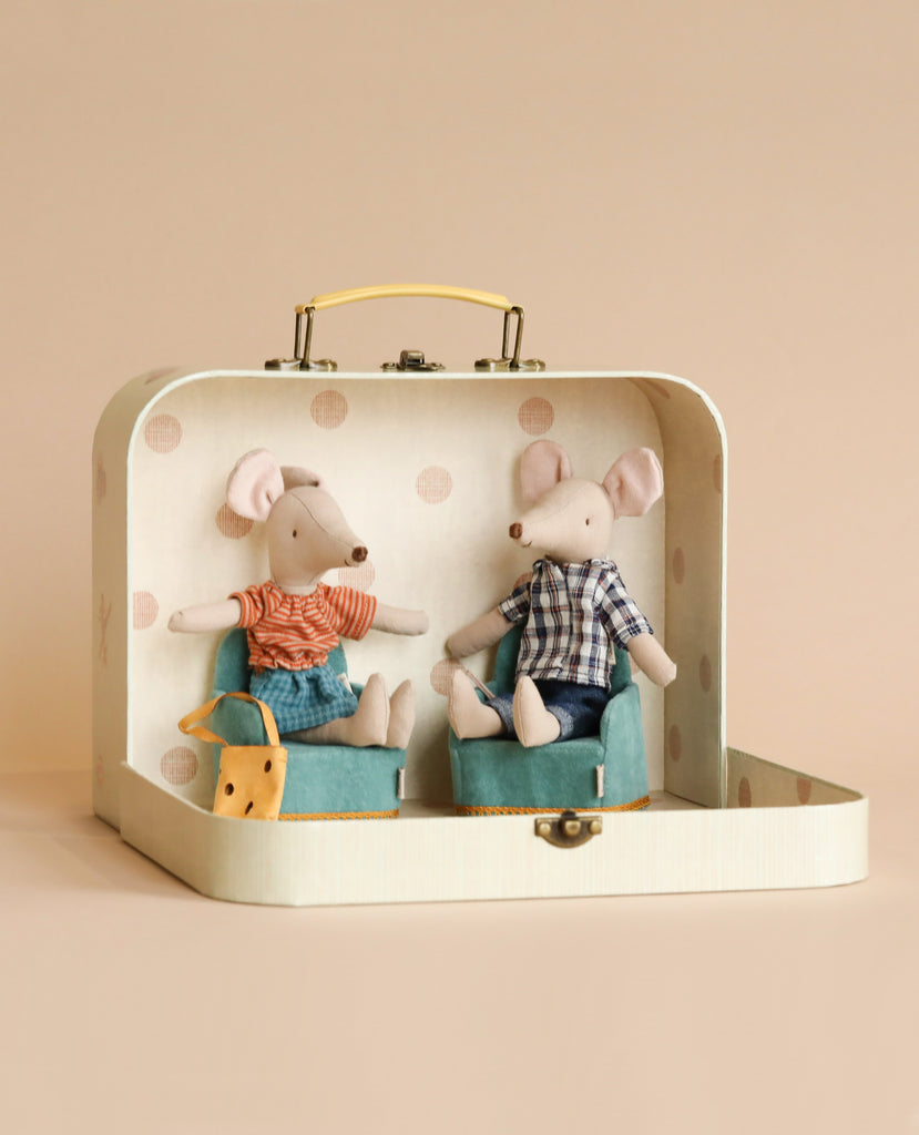 Two Maileg Starter Set - The Parents dolls, portraying a mouse mom and dad, sitting inside a decorated suitcase, one wearing a striped shirt and suspenders, the other in a checkered shirt. A small plush dog sits