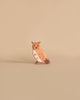 A small, brown and white owl figurine from the Holztiger Handmade Wooden Woodland Animals Set stands against a beige background, evoking the charm of classic wooden animal toys.