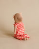 A handmade Maileg Pig In A Dress doll sits against a plain beige background. The pig has an adorable, simplistic design with visible stitches and a weighted bottom.