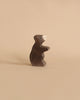 A small brown bear from the Holztiger Handmade Wooden Woodland Animals Set, handcrafted from maple and beech wood, stands upright on a plain beige background.