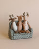 Three small deer stuffed animals sitting on a couch together. 