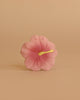 Iris the Hibiscus Teething Toy features a single pink hibiscus flower with a yellow stamen, centered against a plain beige background—an elegant and soothing sensory teether for babies.
