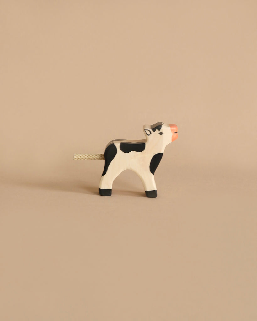 Holztiger Handmade Wooden Black & White Cow Family Set featuring a handcrafted wooden cow with black spots, a pink muzzle, and a cord tail, perfect for imaginative play.