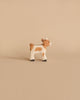 A Holztiger Handmade Wooden Animal Play Set brown and white calf figurine, featuring European craftsmanship, stands on a plain beige background.