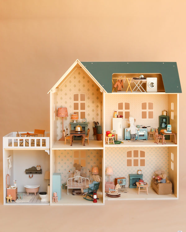 The Maileg Fully Furnished Dollhouse Set (Restock Expected In August) is a beautifully detailed miniature home featuring multiple rooms—kitchen, bathroom, bedroom, living room, and laundry area—each thoughtfully decorated with charming dollhouse furniture and accessories. Plus, enjoy a special gift with purchase!.