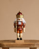 The Christian Ulbricht Collectible Wooden Nutcracker - King (Natural and Gold) stands on a rustic wooden table against a plain beige background, featuring a golden crown, gold staff, white hair, and natural finish.