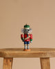 A Christian Ulbricht Collectible Wooden Nutcracker - Mouse King stands on a wooden stool against a plain beige background.