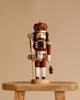 The Christian Ulbricht Collectible Wooden Nutcracker Gingerbread King (Natural) stands 15 inches tall, crafted from solid wood in Germany, holding a staff with a heart-shaped top and a gingerbread figure, set against a plain beige background.