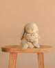 Snuggle Bunnies - Frankie the Hugging Bunny - Caramel sits on a wooden stool against a plain beige background, cuddling a smaller plush toy.