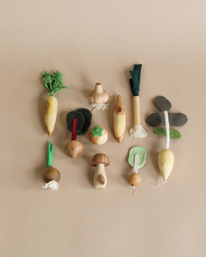 wooden vegetables laying flat on a beige background