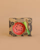 The Wally the Watermelon Bowl & Spoon Set by Oli & Carol is a boxed dinnerware set for babies 6+ months, featuring a watermelon-themed plate, non-toxic bowl, and matching green wooden spoon against a plain beige background.