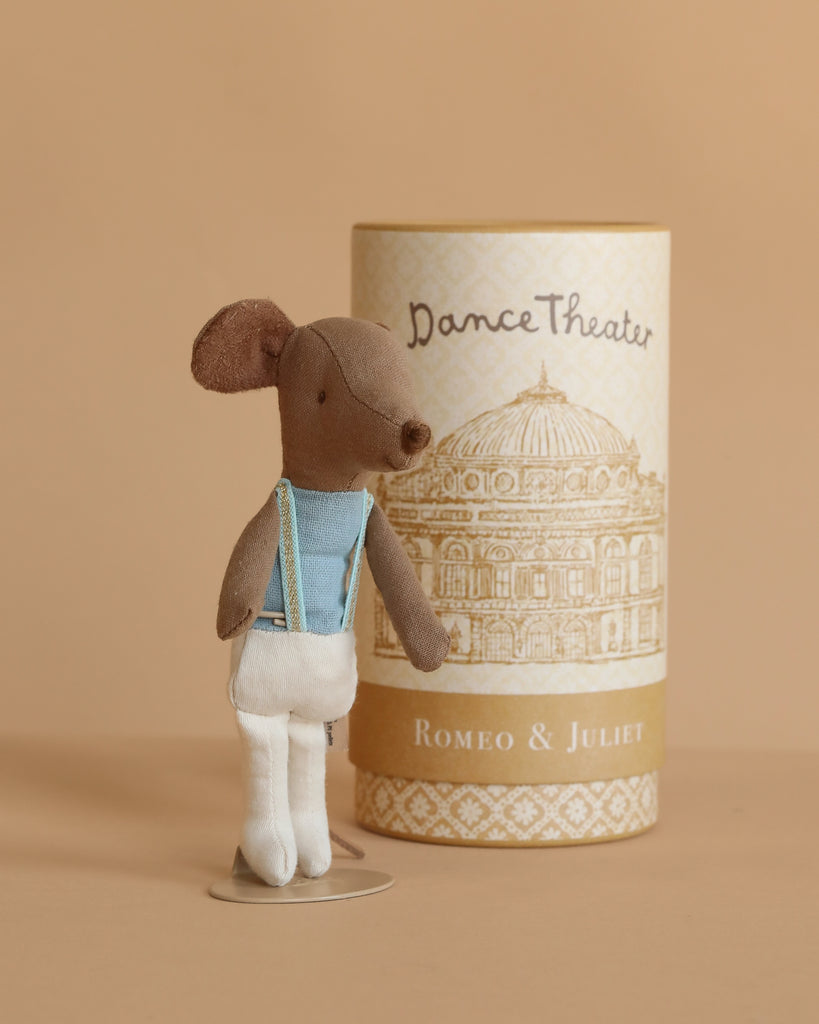 The Maileg Ballet Dancer Mouse, Big Brother wears a blue top and white tights and stands before a "Dance Theater Romeo & Juliet" box with a gold theater design—an adorable collectible display for any ballet or mouse fan.