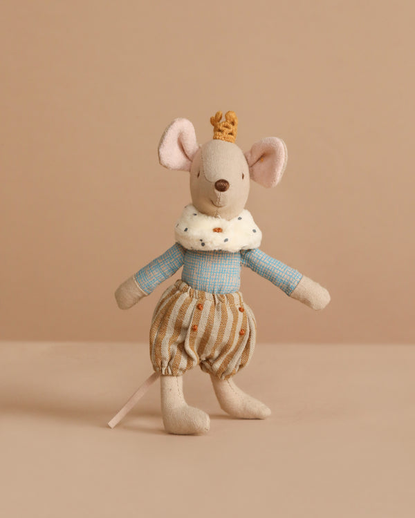 The Maileg Prince Mouse, Big Brother stands upright in a blue shirt with white ruffled collar and striped pants. Made of cotton polyester, this charming stuffed toy is set against a beige background and recommended for ages 3+.