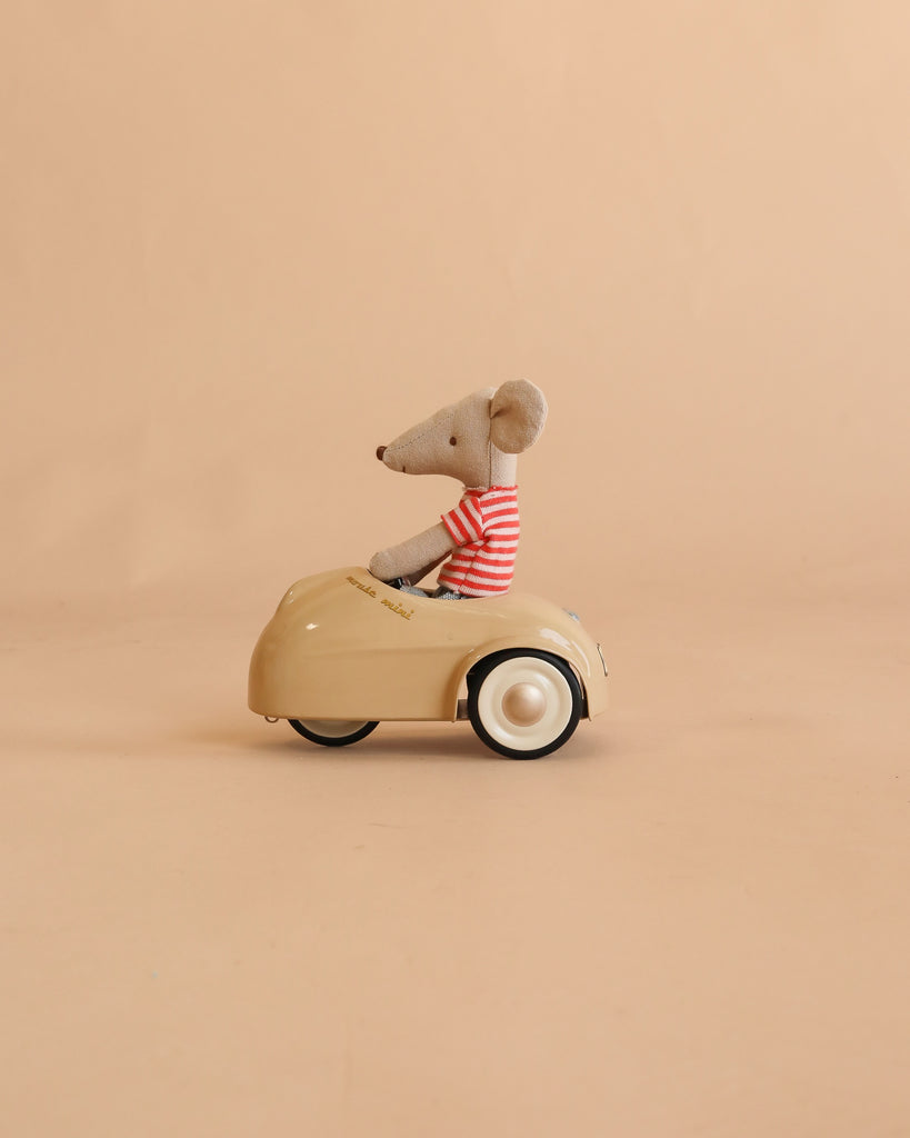 A Maileg LouiMax and Stella Adventure Set, featuring a plush LouiMax mouse in a red striped shirt seated in a small beige car, is displayed against a plain beige background.