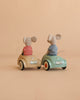 Two Maileg mice from the LouiMax and Stella Adventure Set, both dressed in striped shirts, sit in small toy cars—one beige and one light blue—with license plates and red wheel detailing. They face away against a plain beige background, ready for Little Brother and Sister Mice adventures.