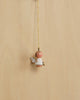 The Christian Ulbricht Ornament - Angel (White) features a small, handmade angel with brown hair, rosy cheeks, white wings with black spots, and a gold halo hanging from a thin gold string. Contains small parts; choking hazard.