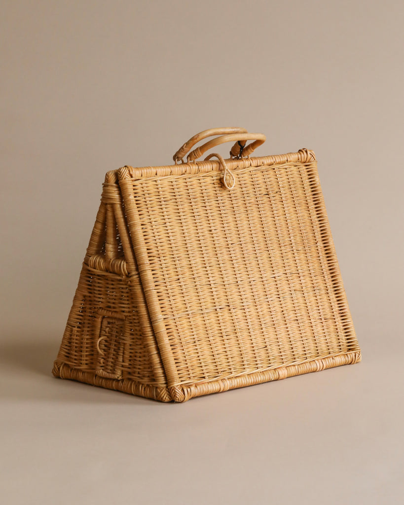 A stylish braided A-Frame Dollhouse handbag with a triangular shape and a single top handle, set against a neutral beige background.