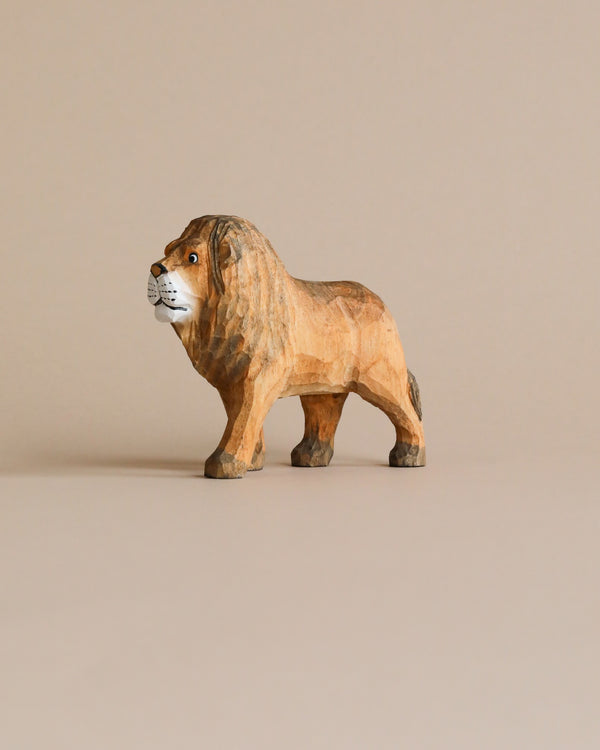 A Hand Carved Wooden Lion figurine with detailed carving stands against a plain beige background, showcasing a realistic mane and expressive face.
