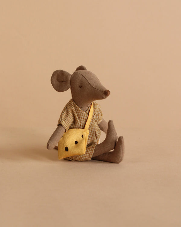 The Maileg Mum Mouse - Light Brown, dressed in a checked outfit and yellow crossbody bag, sits on a beige background—ready for adventures and searching for cheese holes.